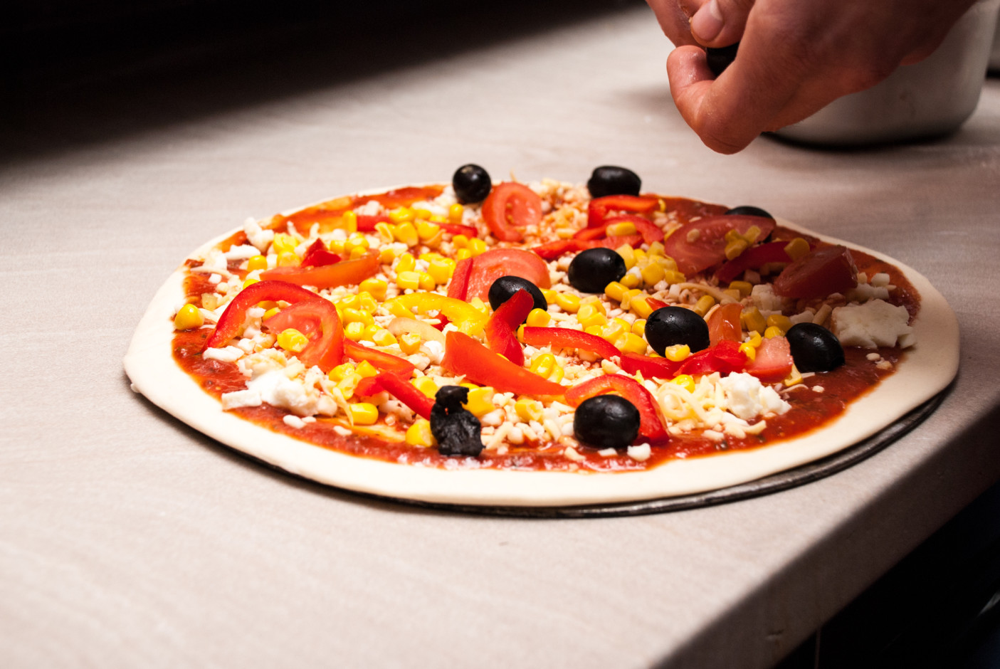 Rozłożyć składniki. Nie za dużo, bo wtedy pizza zrobi się mokra, a ciasto nie będzie chrupiące.